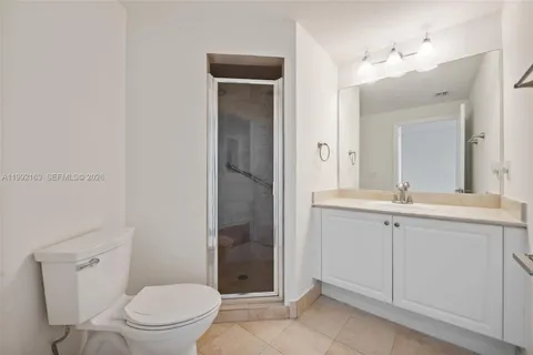 a spacious bathroom with a granite countertop sink a toilet and a mirror