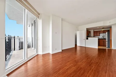 a view of a big room with wooden floor and windows