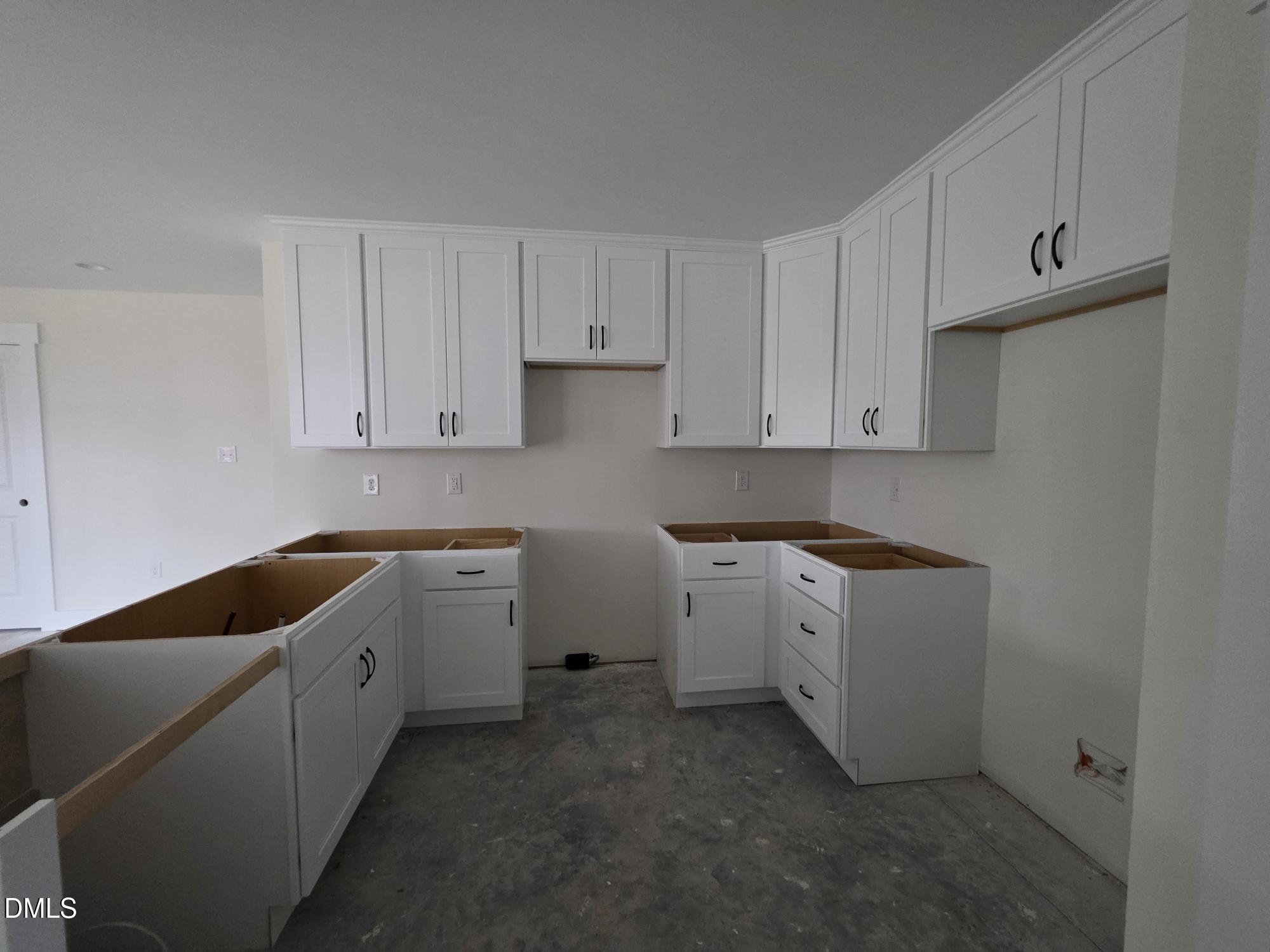 307 East Holmes Street Benson, NC 27504 - Photo 9 of 15 a kitchen with white cabinets and white appliances