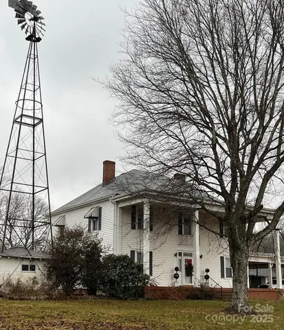 a front view of a house with a yard and potted plants