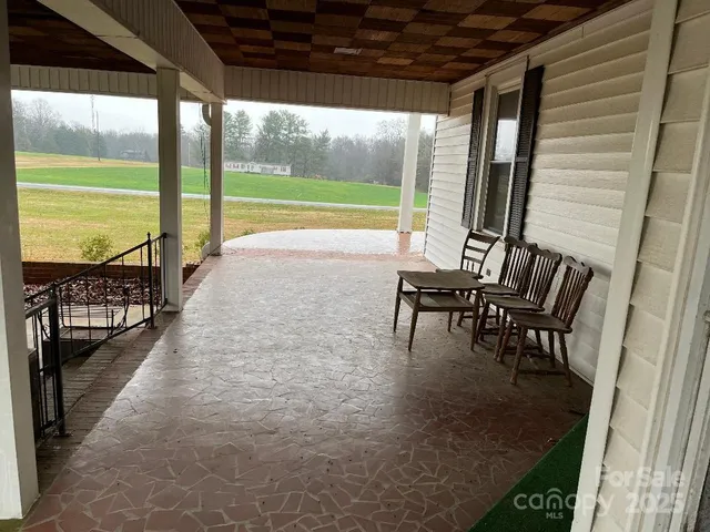 a view of a porch with chairs and backyard