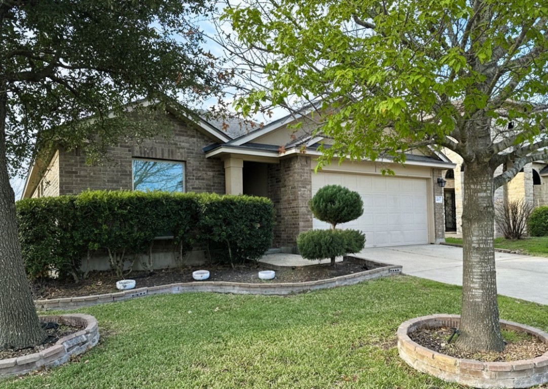 1437 April Meadows Loop Georgetown, TX 78626 - Photo 1 of 27 a front view of a house with a garden and plants