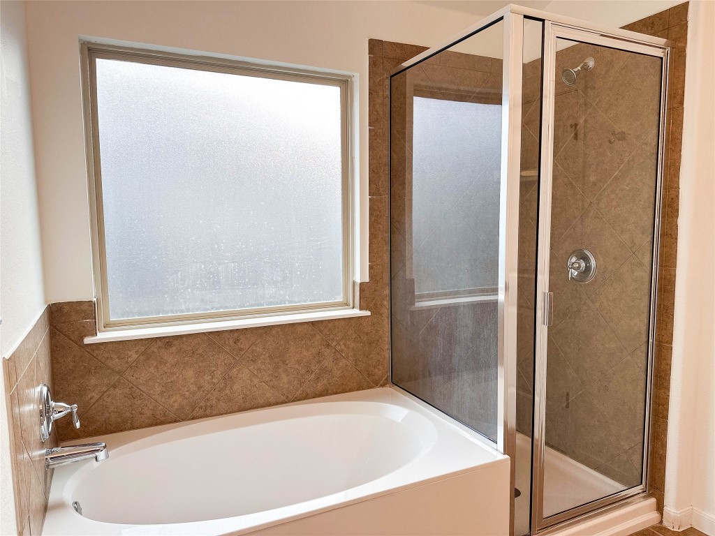 1437 April Meadows Loop Georgetown, TX 78626 - Photo 15 of 27 a bathroom with a bathtub and a shower