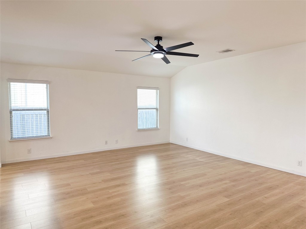 1437 April Meadows Loop Georgetown, TX 78626 - Photo 4 of 27 an empty room with wooden floor fan and windows