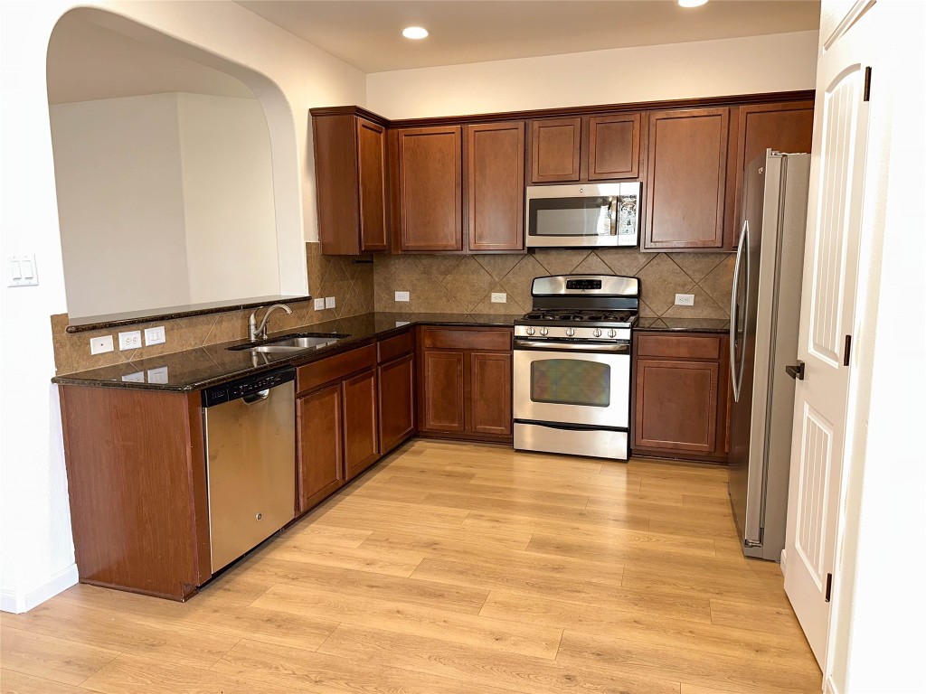 1437 April Meadows Loop Georgetown, TX 78626 - Photo 9 of 27 a kitchen with granite countertop a stove top oven and cabinets