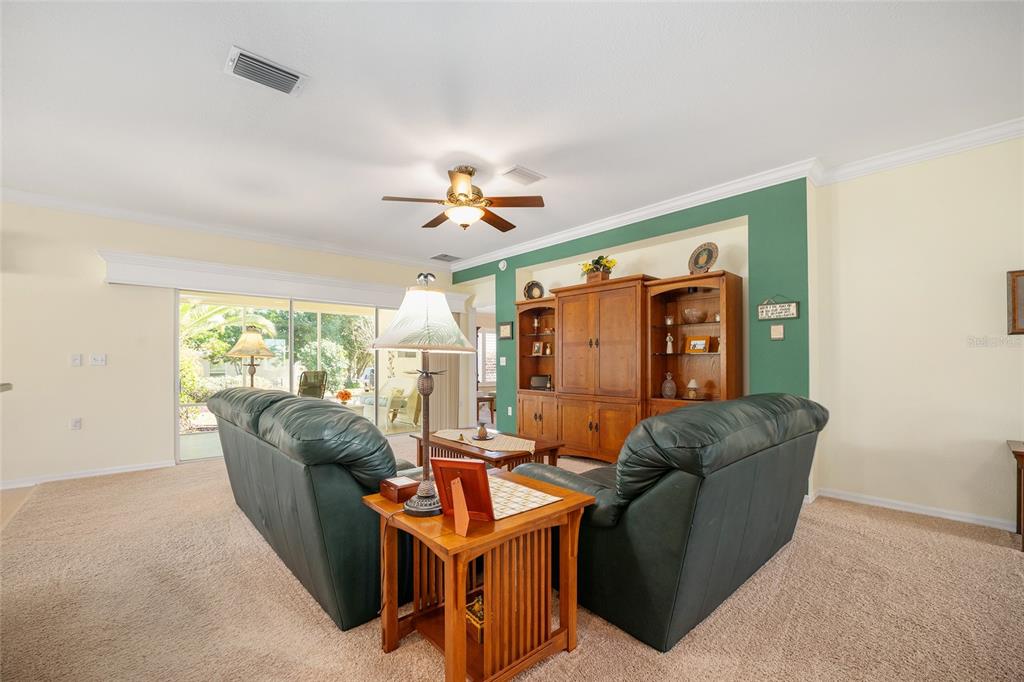 12309 Southeast 92nd Court Road Summerfield, FL 34491 - Photo 11 of 81 a living room with furniture a chandelier and a large window