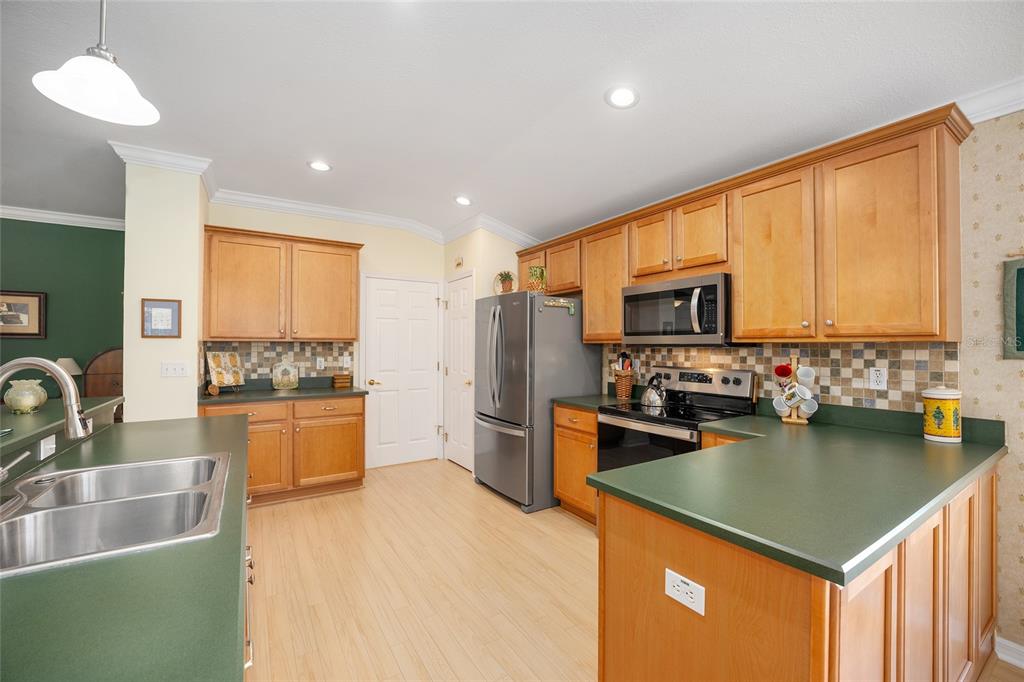12309 Southeast 92nd Court Road Summerfield, FL 34491 - Photo 21 of 81 a kitchen with a refrigerator a sink dishwasher stove and oven with wooden floor
