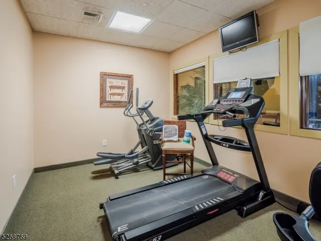 a room with gym equipment and wooden floor