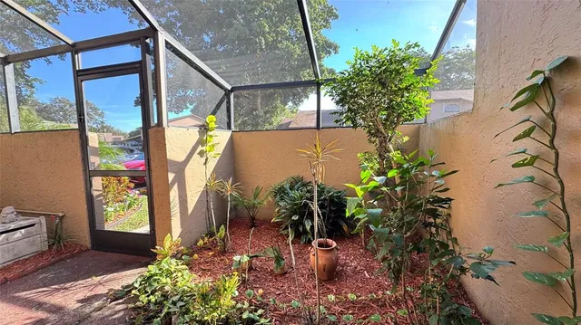 a view of yellow house with a flower garden