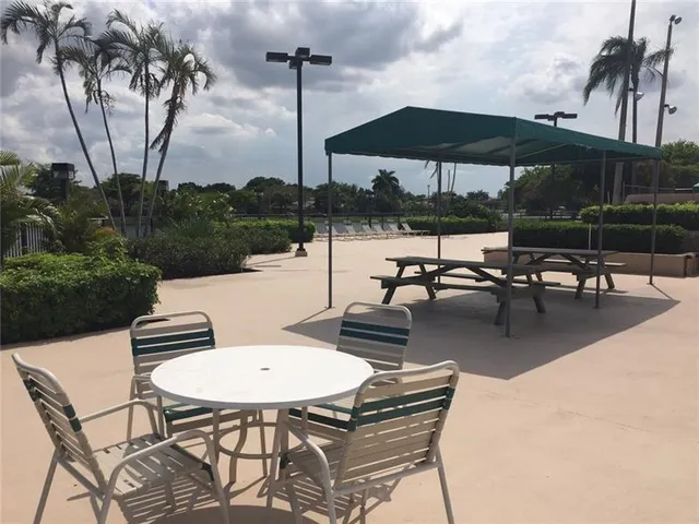 a view of a patio with chairs and table under an umbrella