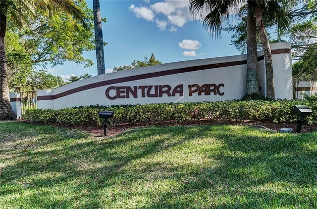 a view of a street sign under a large tree