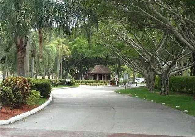a view of a house with a yard and large trees