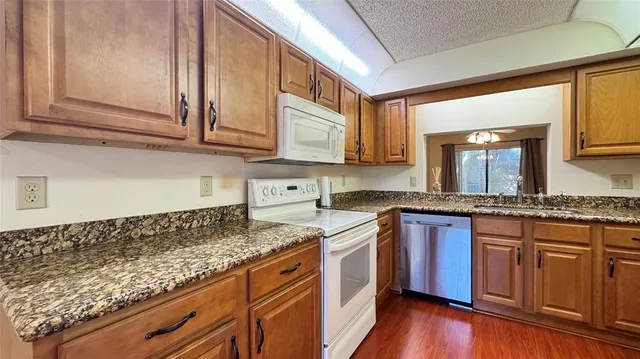 a kitchen with stainless steel appliances granite countertop a stove a sink and a white cabinets