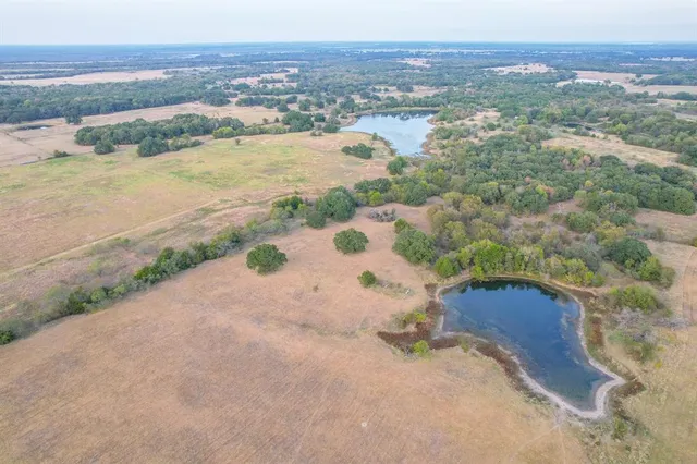 a view of a lake in middle of a field