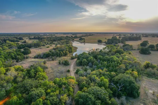 an aerial view of a houses with outdoor space and trees