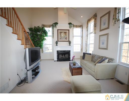 11 Gramercy Road Monmouth Junction, NJ 08852 - Photo 11 of 25 a living room with furniture a flat screen tv and a fireplace