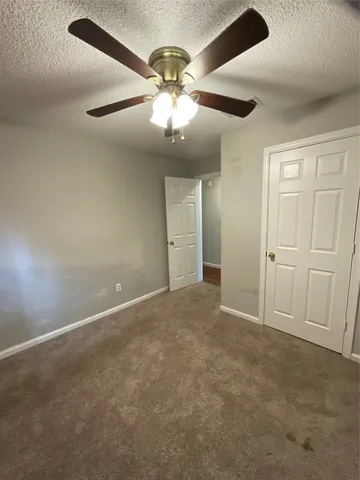 en empty room with windows and fan