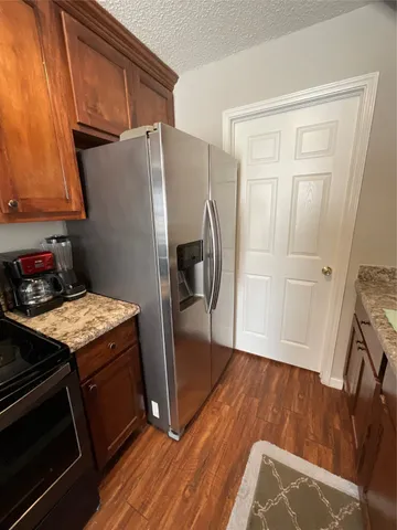 a kitchen with a refrigerator and a stove top oven