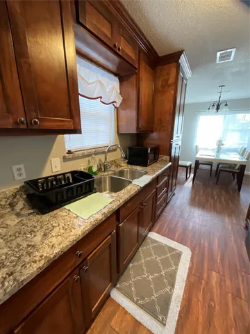 a kitchen with granite countertop wooden floors and sink
