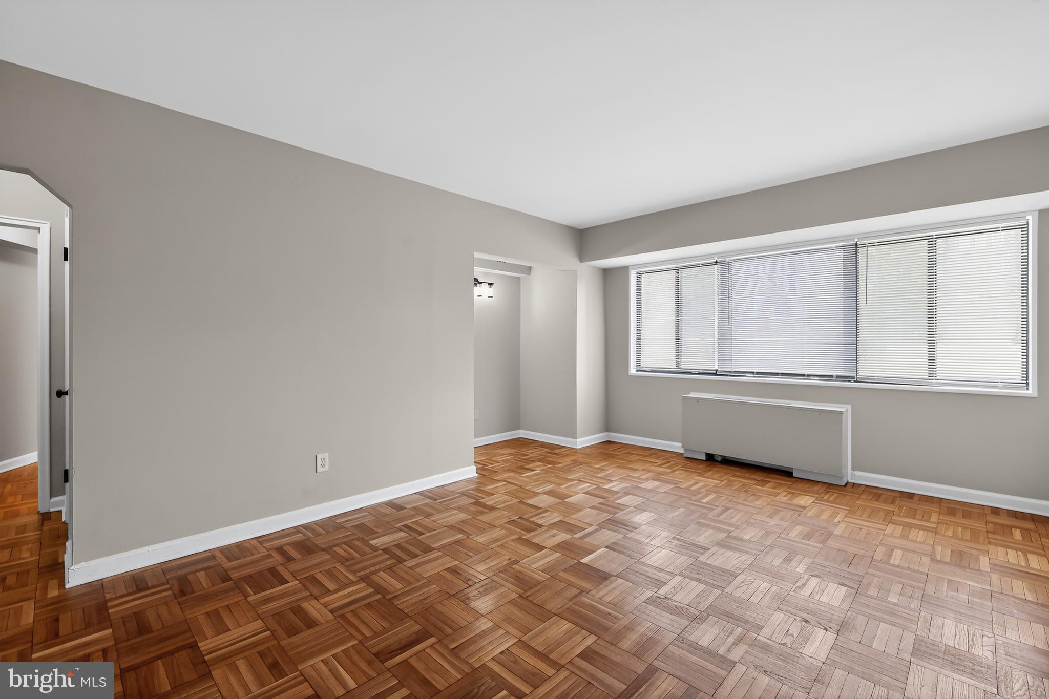 3701 Connecticut Avenue Northwest, Unit 233 Washington, DC 20008 - Photo 12 of 31 a view of an empty room with wooden floor and a window
