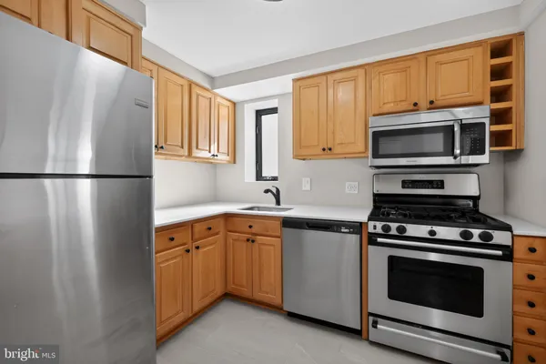 a kitchen with cabinets appliances a sink and a window