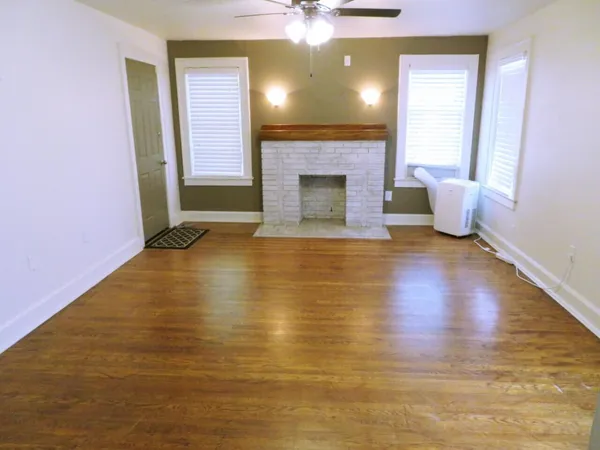 a view of an empty room with a fireplace and a window