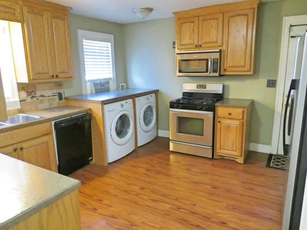 a kitchen with stainless steel appliances granite countertop a stove a sink and a microwave