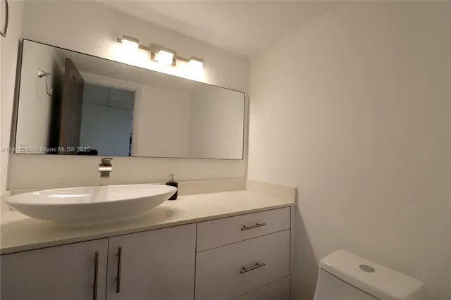a bathroom with a sink a toilet and mirror