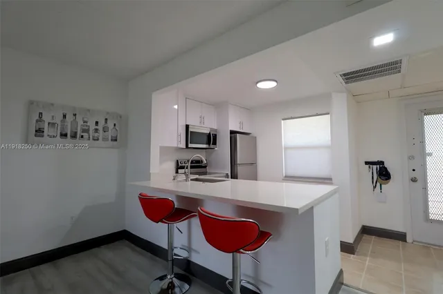 a kitchen with stainless steel appliances kitchen island granite countertop a refrigerator a stove a sink dishwasher with a dining table and chairs