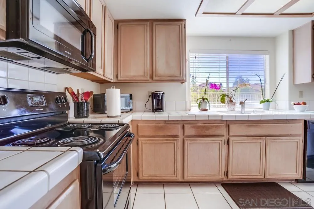 3243 San Tomas Drive Oceanside, CA 92056 - Photo 24 of 45 a kitchen with stainless steel appliances granite countertop a sink stove and cabinets