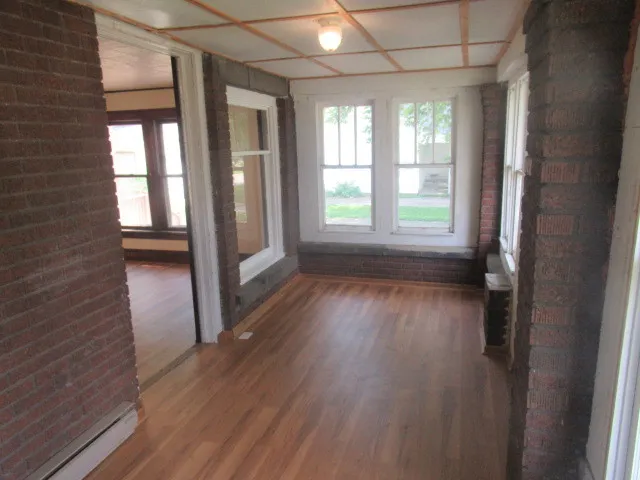 a view of hallway with a wooden floor and a window