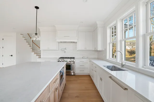 an empty room with wooden floor windows and ceiling fan