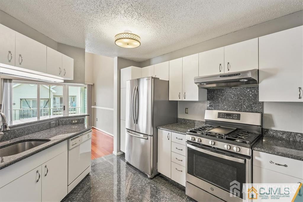 834 Edpas Road New Brunswick, NJ 08901 - Photo 9 of 20 a kitchen with stainless steel appliances granite countertop a stove a refrigerator and a granite counter tops with wooden floors