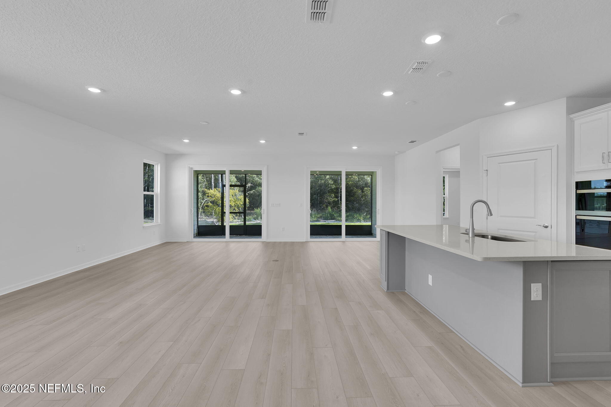 134 Headstream Drive St. Johns, FL 32259 - Photo 4 of 28 a large kitchen with stainless steel appliances a large counter top a wooden floors and a large window