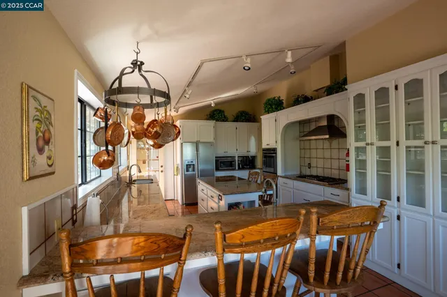 a kitchen with kitchen island granite countertop a stove and a sink