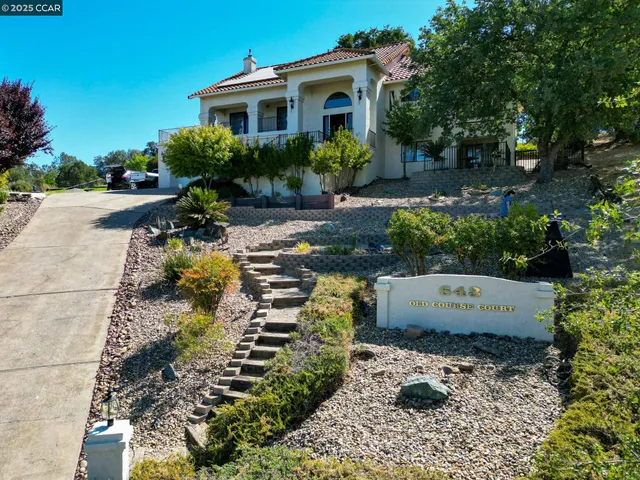 an aerial view of residential houses with outdoor space and trees