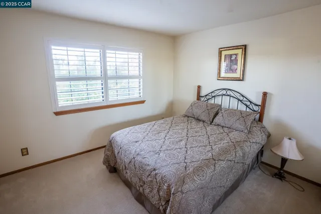 a bedroom with a bed lamp and a window