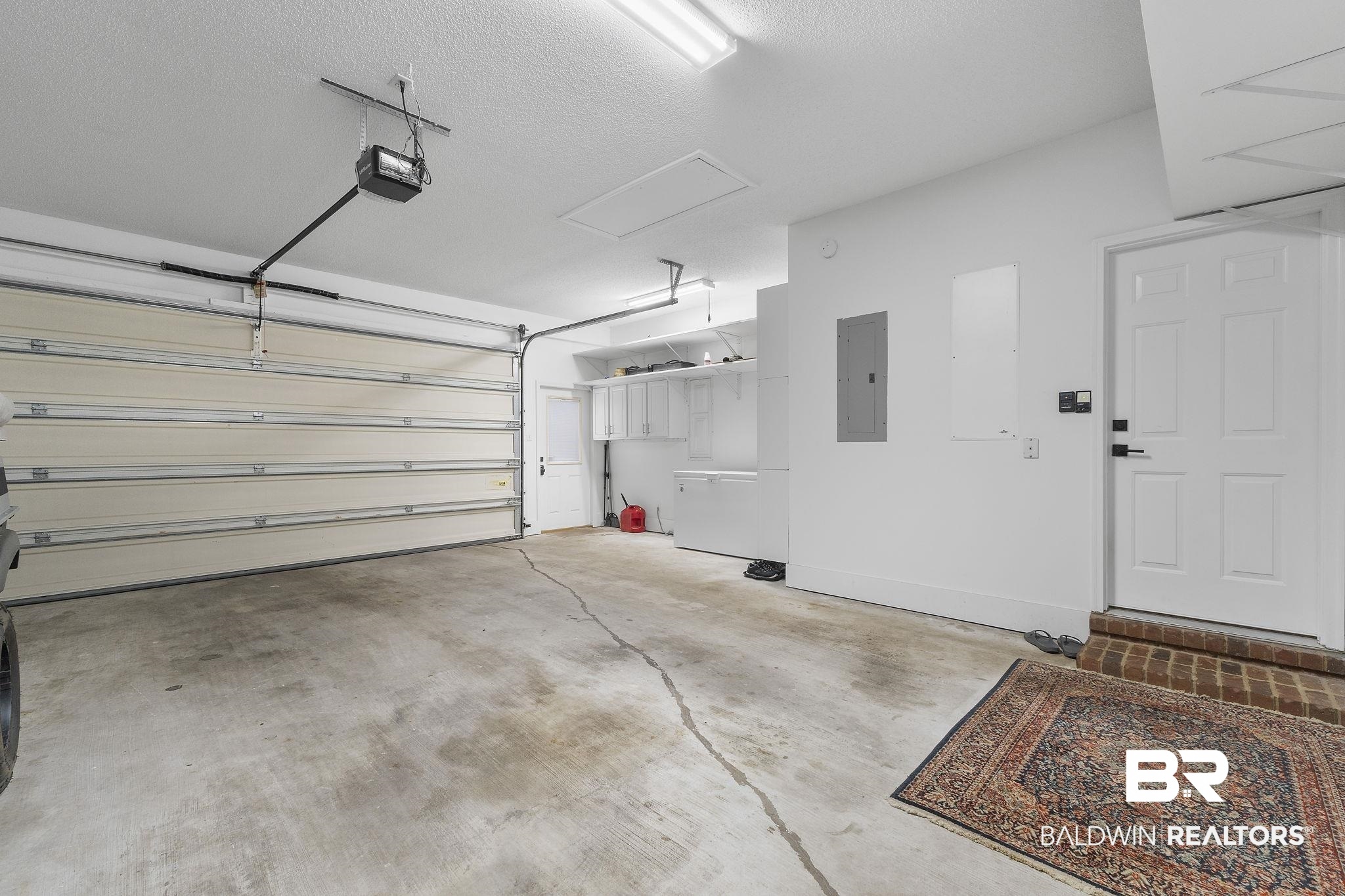 4451 Millhouse Road Gulf Shores, AL 36542 - Photo 40 of 50 Garage featuring a garage door opener and electric panel