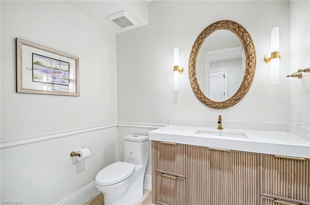 1888 6th Street South Naples, FL 34102 - Photo 36 of 37 a bathroom with a sink mirror and toilet
