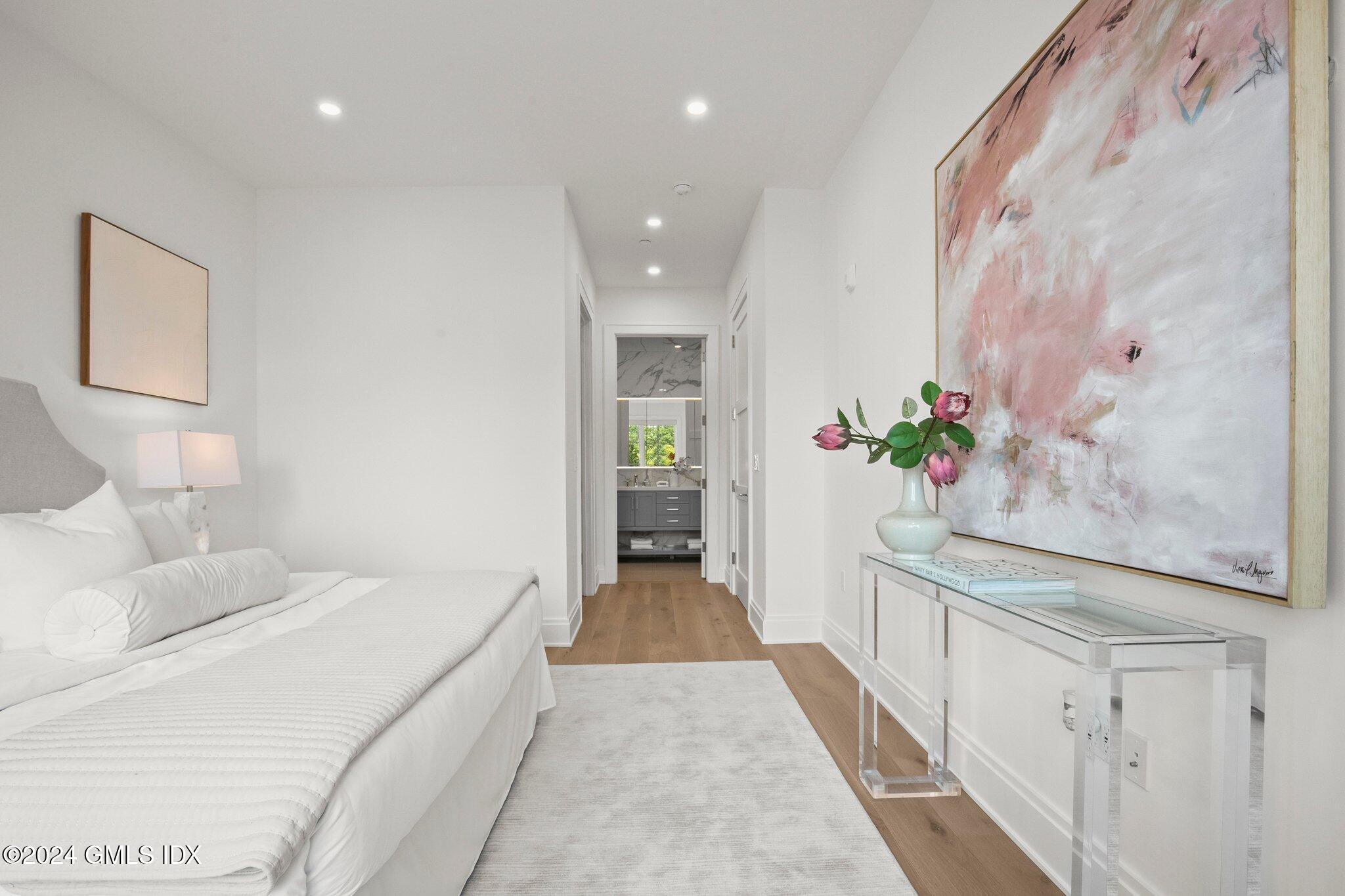 71 Havemeyer Place, Unit 303S Greenwich, CT 06830 - Photo 17 of 26 a spacious bedroom with a bed and a chandelier