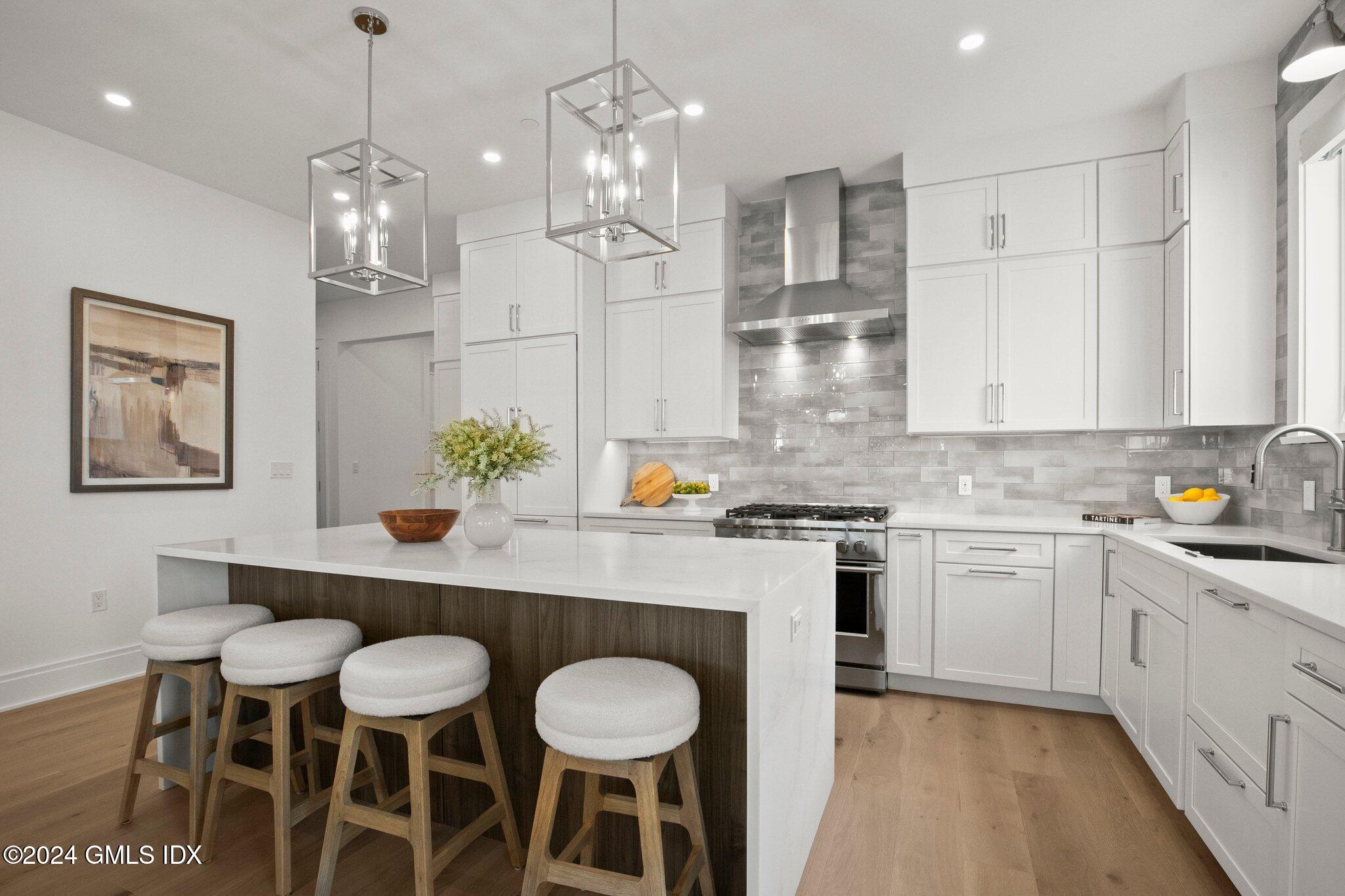 71 Havemeyer Place, Unit 303S Greenwich, CT 06830 - Photo 4 of 26 a kitchen with kitchen island granite countertop a dining table chairs cabinets and stainless steel appliances