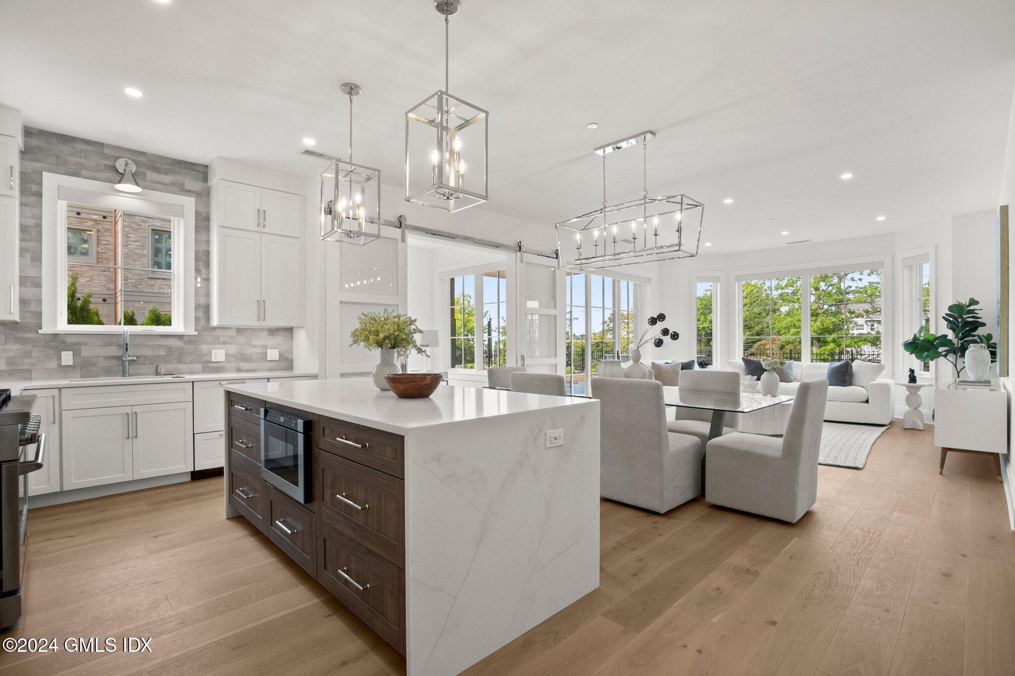 71 Havemeyer Place, Unit 303S Greenwich, CT 06830 - Photo 6 of 26 a large white kitchen with a large island oven a stove and a chandelier