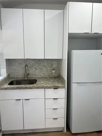 a kitchen with cabinets and white stainless steel appliances
