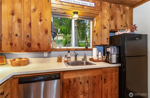 a kitchen with stainless steel appliances a sink cabinets and a window