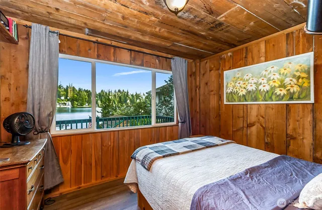 a bedroom with large window and a bed