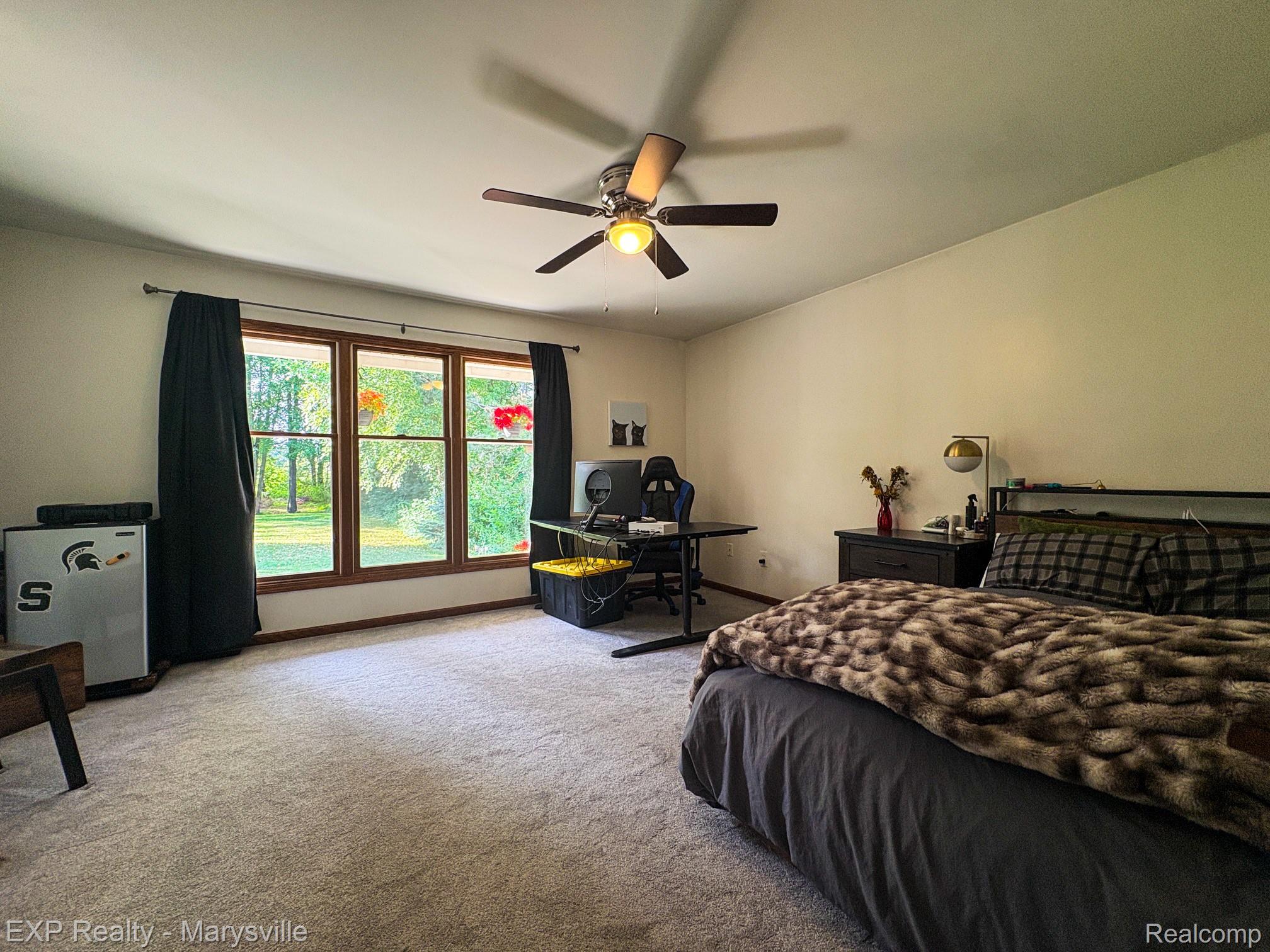 5538 Klettner Road St. Clair, MI 48079 - Photo 26 of 46 Spacious room featuring a multi-pane window with wood-finish trim, a ceiling fan with integrated lighting, and neutral-toned wall paint