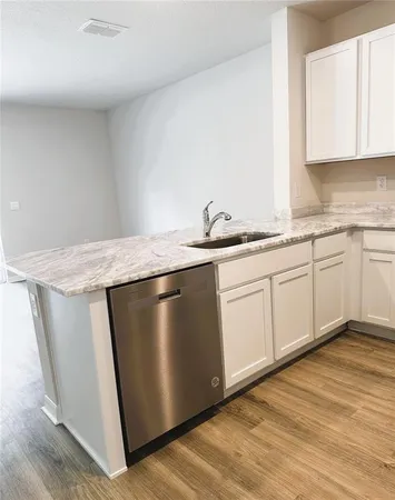 a kitchen with stainless steel appliances granite countertop a sink a stove a microwave and wooden cabinets