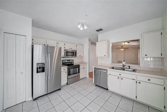 a kitchen with white cabinets and stainless steel appliances