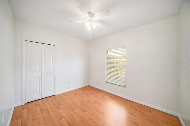 an empty room with windows and fan