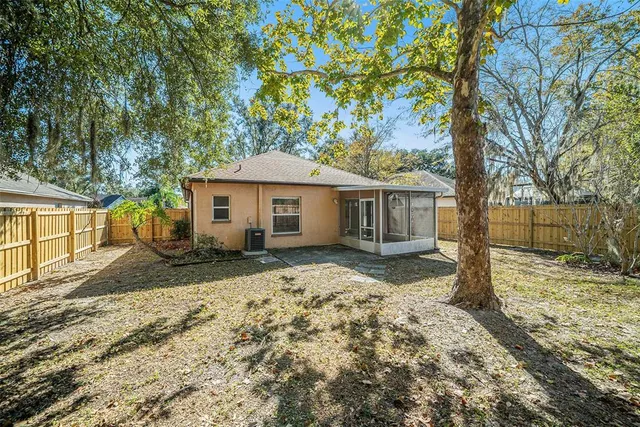 a view of a yard in front of a house with large tree